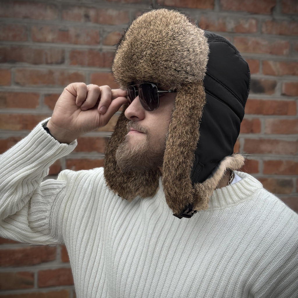 Man wearing a black rabbit fur ushanka hat with ear flaps down