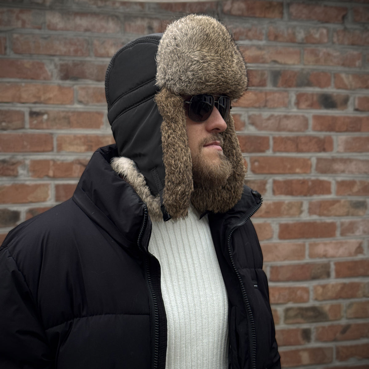 Three-quarter view of black winter ushanka hat with natural rabbit fur